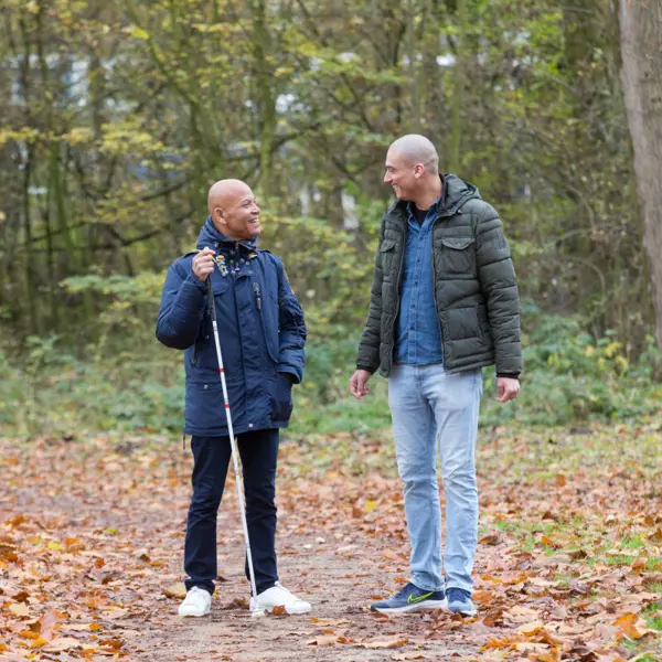 Cliënt loopt samen met ambulant specialistisch begeleider door het bos. Cliënt loopt samen met ambulant specialistisch begeleider door het bos.