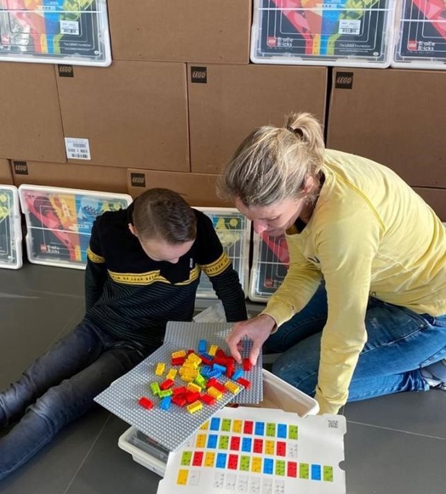 Leerling en docent Visio Onderwijs onderzoeken de nieuwe Lego Braille Bricks