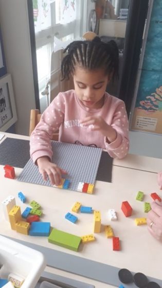 Meisje van kleutergroep Visio Onderwijs Amsterdam voelt aan Lego Braille Bricks