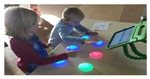 Kinderen die spelen met de zes interactieve knoppen van Cosmoids