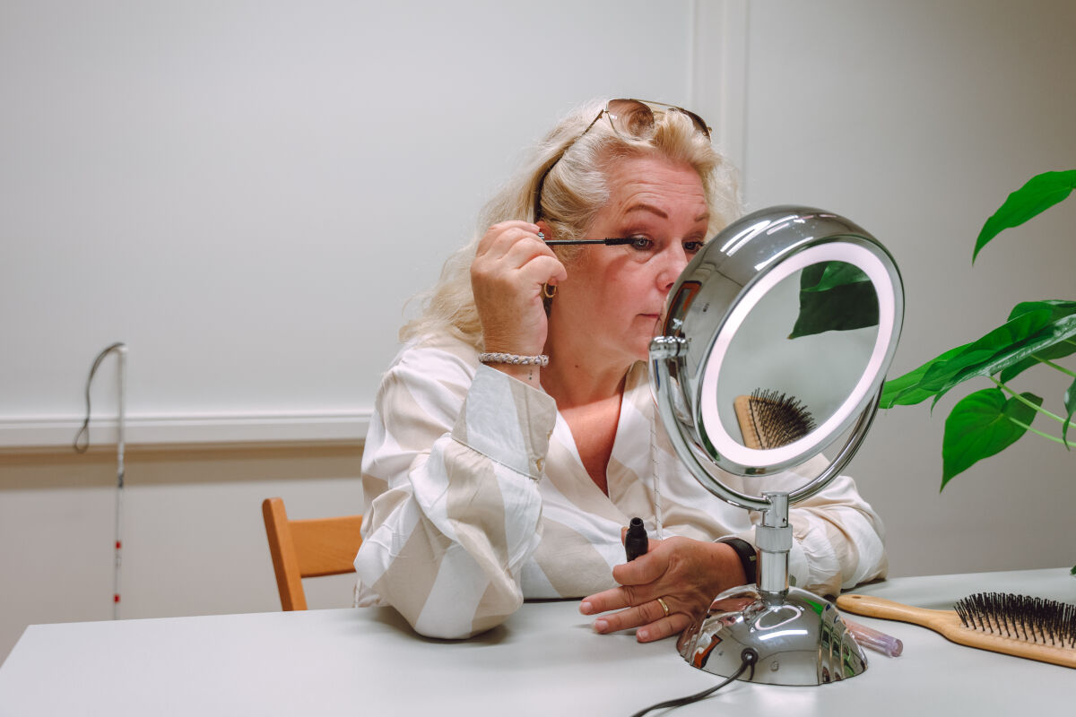 Slechtziende vrouw maakt zichzelf op in de spiegel 