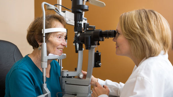 Slechtziende vrouw krijgt oogonderzoek door optometrist Slechtziende vrouw krijgt oogonderzoek door optometrist