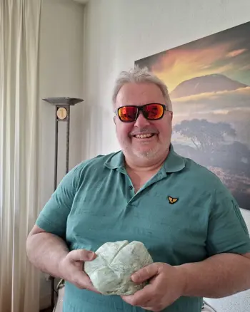 Joska Wolthuis laat zijn speksteen aan de camera zien. Hij draagt een zonnebril en glimlacht naar de camera. Joska Wolthuis laat zijn speksteen aan de camera zien. Hij draagt een zonnebril en glimlacht naar de camera.