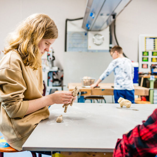 Meisje werkt met klei in een klaslokaal. Meisje werkt met klei in een klaslokaal.