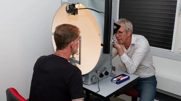 Cliënt en optometrist tijdens het visueel functieonderzoek Cliënt en optometrist tijdens het visueel functieonderzoek