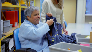 Cliënt vult tasjes met materialen bij het Visio Elizabeth Kalishuis Cliënt vult tasjes met materialen bij het Visio Elizabeth Kalishuis