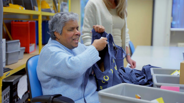 Cliënt vult tasjes met materialen bij het Visio Elizabeth Kalishuis Cliënt vult tasjes met materialen bij het Visio Elizabeth Kalishuis