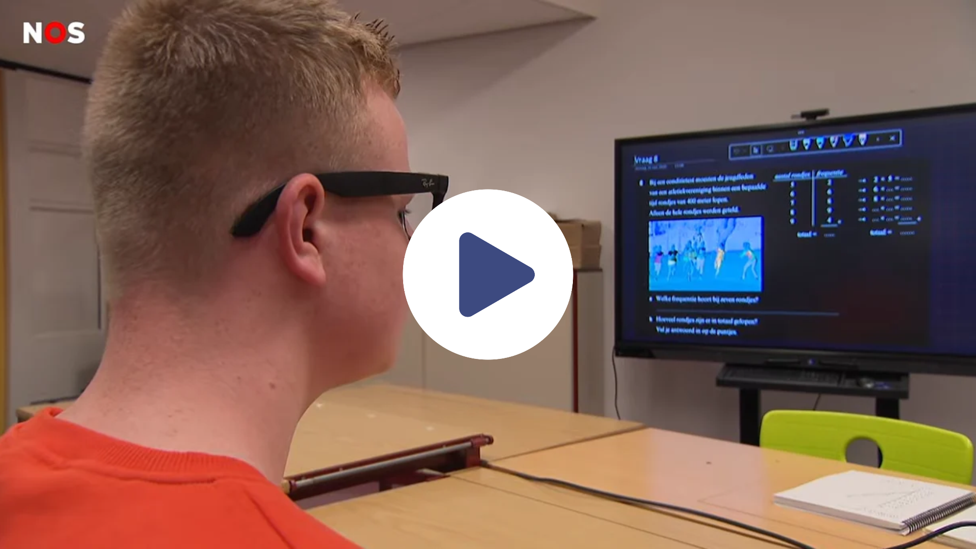 Xavi kijkt met zijn Meta-bril op naar een computerscherm. Er staat een play-knop op de afbeelding. 