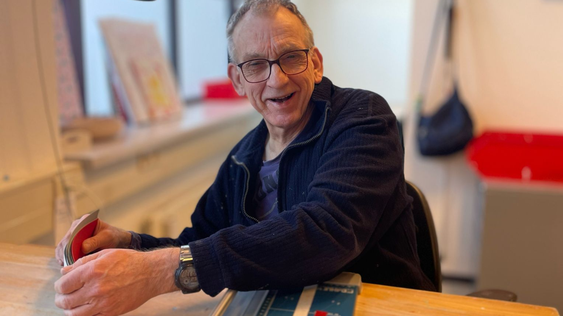 Mannelijke cliënt werkt aan tafel met een papiersnijapparaat