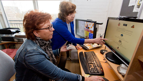 Twee vrouwen voor een computerscherm Twee vrouwen voor een computerscherm