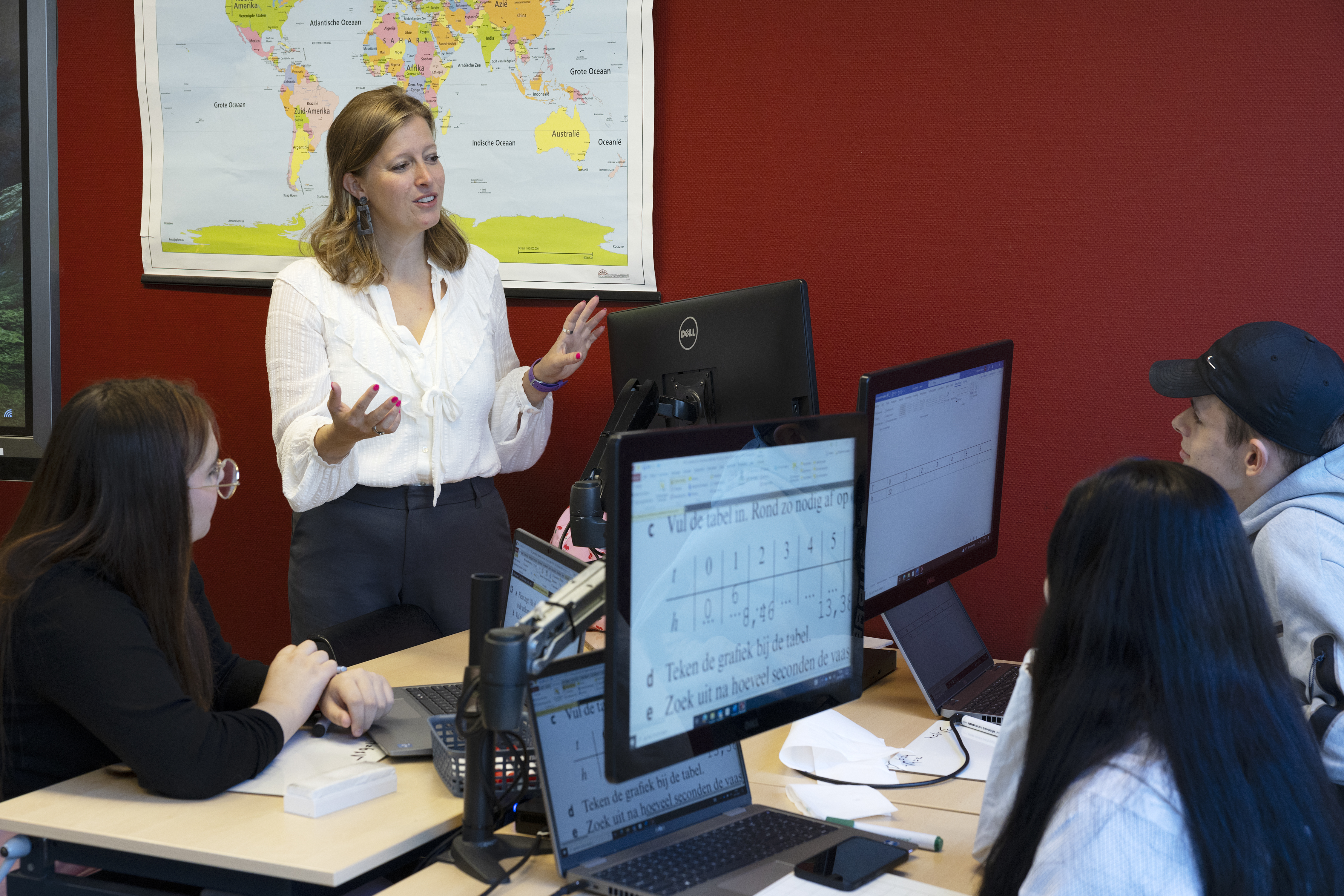 Juf Eva Slootweg in de klas met kinderen achter beeldschermen