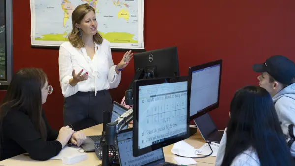 Juf Eva Slootweg in de klas met kinderen achter beeldschermen Juf Eva Slootweg in de klas met kinderen achter beeldschermen