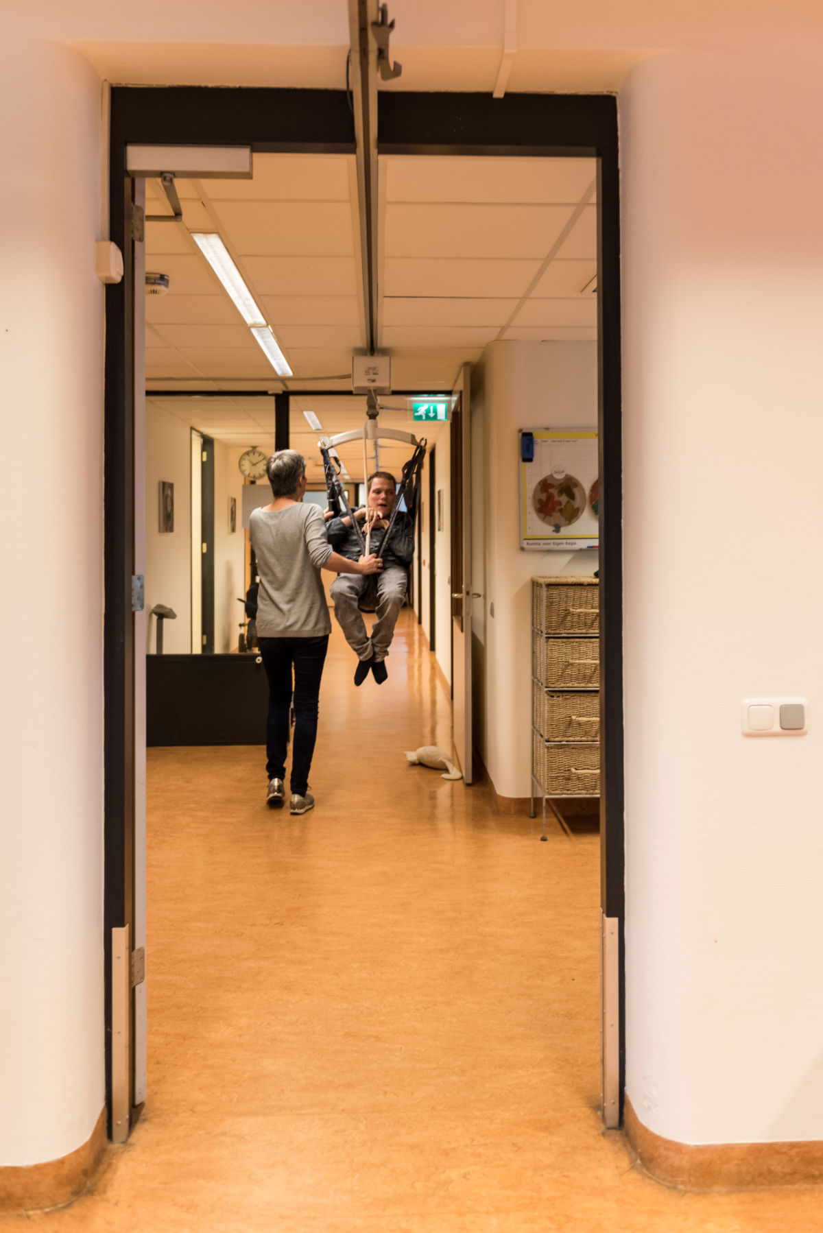 Begeleider ondersteunt cliënt in tillift bij Visio Wonen & Dagbesteding Emmen