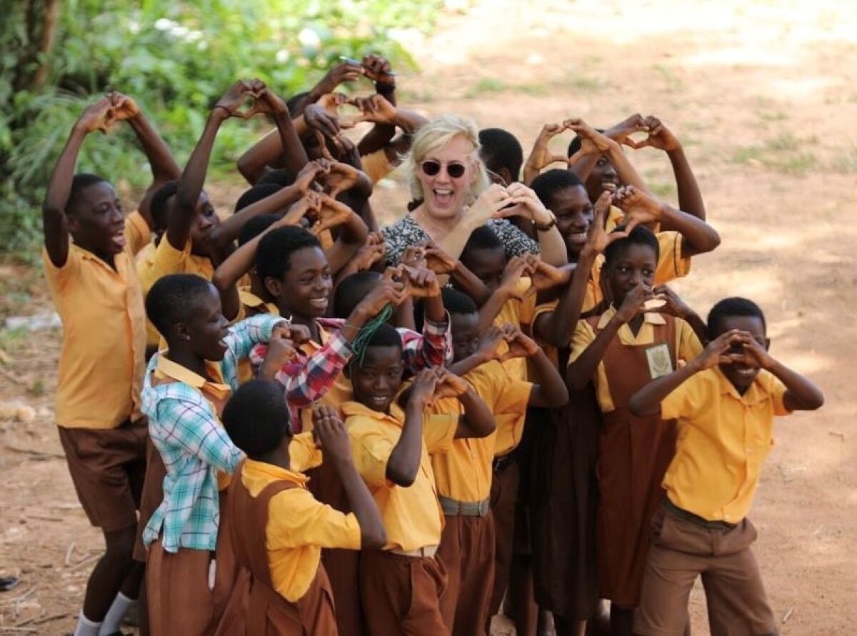Kids in Africa and woman forming hears with their hands