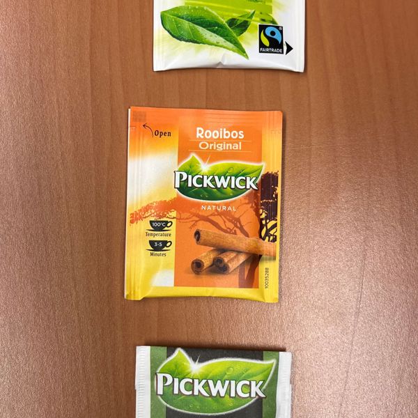 “Drie Pickwick-theezakjes op een houten ondergrond. “Drie Pickwick-theezakjes op een houten ondergrond.