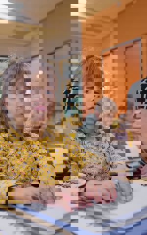 Elena zit in de klas naast de juf. Ze is braille aan het lezen. Elena zit in de klas naast de juf. Ze is braille aan het lezen.