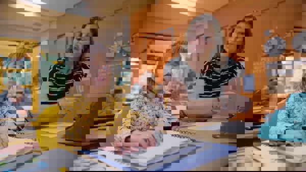 Elena zit in de klas naast de juf. Ze is braille aan het lezen. Elena zit in de klas naast de juf. Ze is braille aan het lezen.