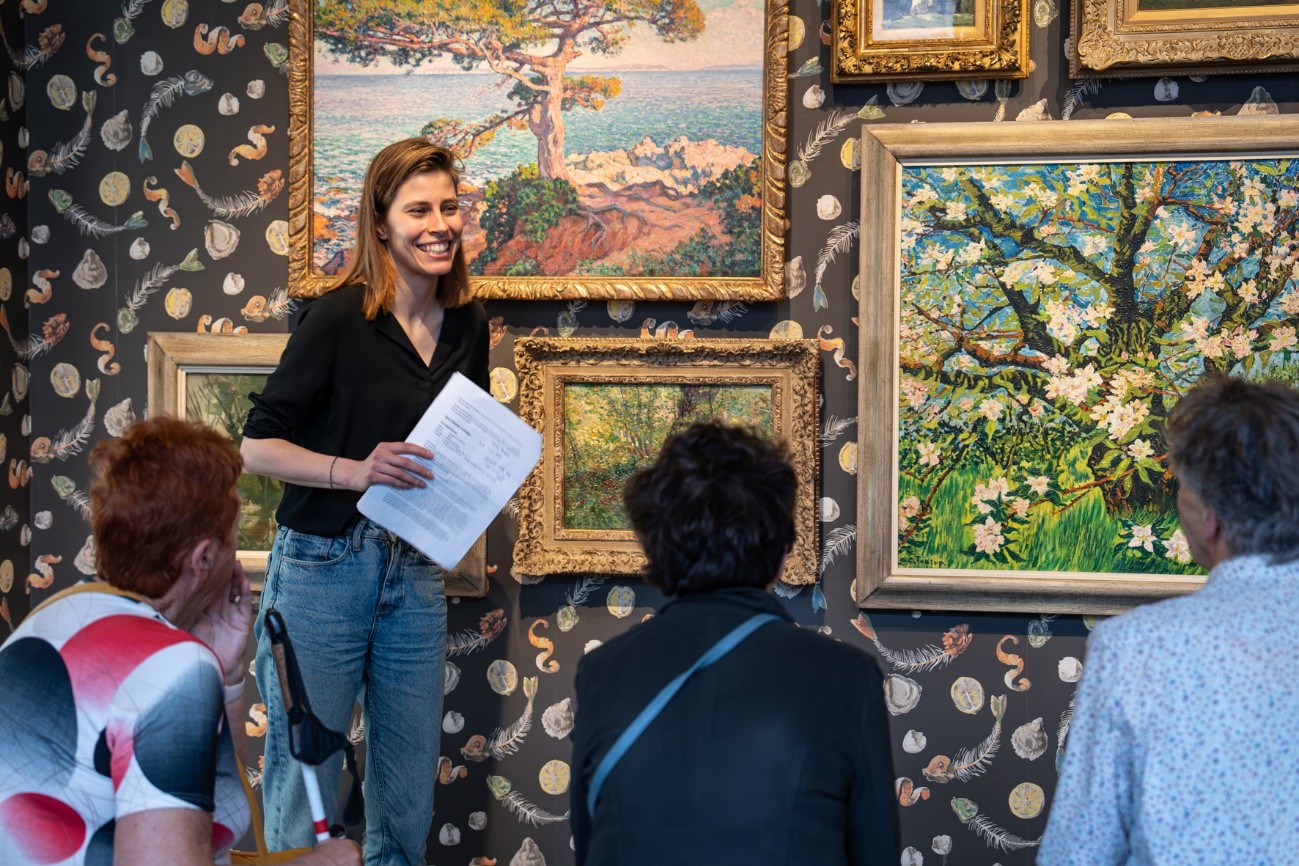 Medewerker van het Centraal Museum geeft rondleiding langs diverse schilderijen