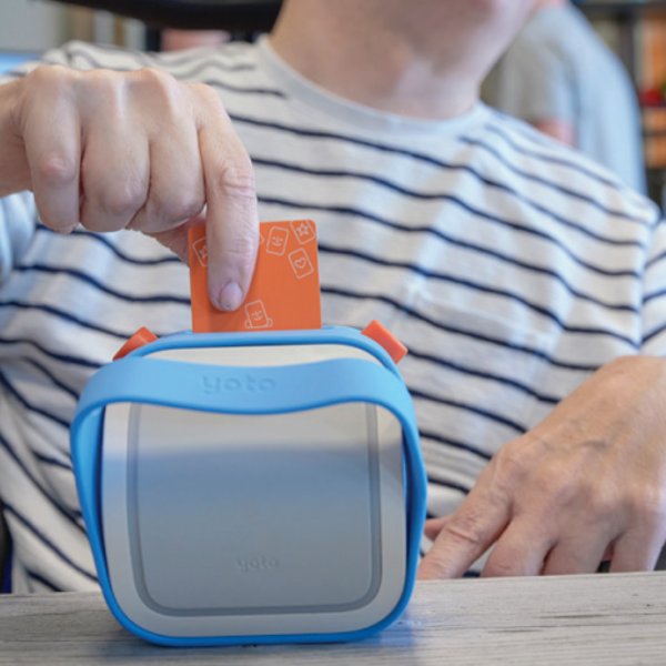 Een man stopt een pasje in de Yoto-muziekspeler. Een man stopt een pasje in de Yoto-muziekspeler.