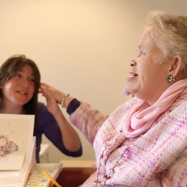 Oudere dame met visuele en verstandelijke beperking en een medewerker Oudere dame met visuele en verstandelijke beperking en een medewerker