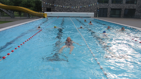 Afbeelding van een zwembad. Meerdere mensen zijn baantjes aan het trekken. Afbeelding van een zwembad. Meerdere mensen zijn baantjes aan het trekken.