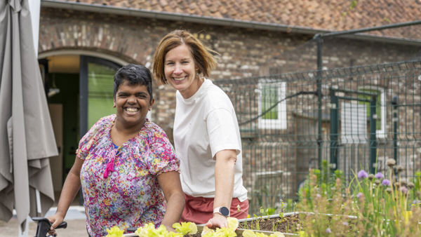 Een medewerker en cliënt van Wonen en Dagbesteding zijn lachend te zien Een medewerker en cliënt van Wonen en Dagbesteding zijn lachend te zien