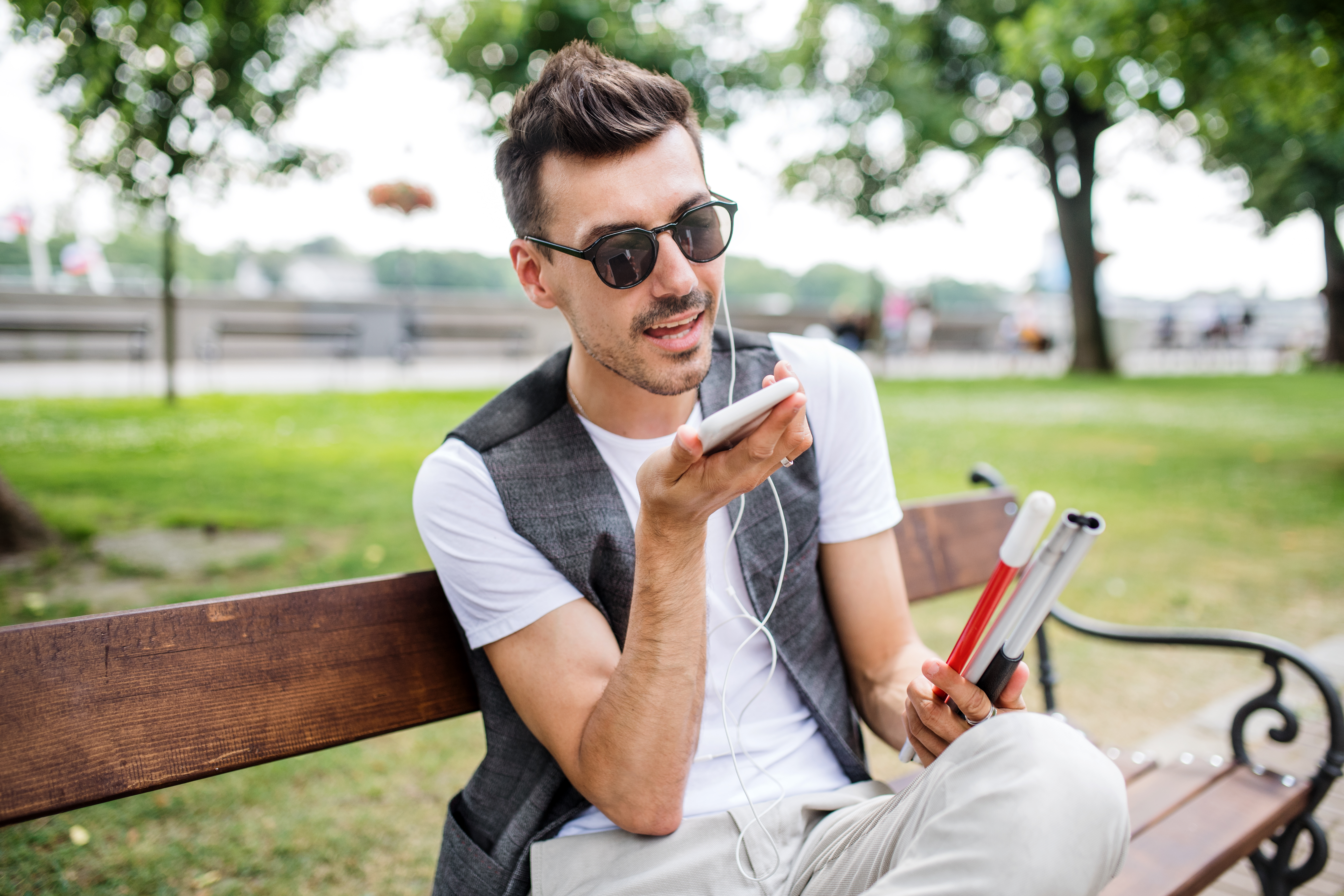 Jongeman Met Smartphone Op Bankje In Park
