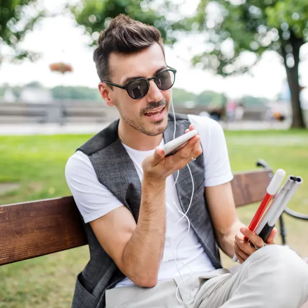 Jongeman Met Smartphone Op Bankje In Park Jongeman Met Smartphone Op Bankje In Park