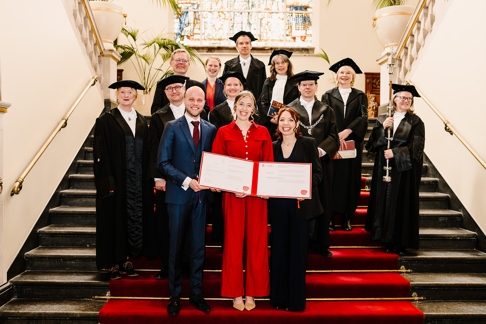 Sarah Tol poseert lachend met haar proefschrift na haar verdediging