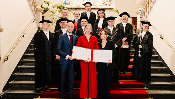 Sarah Tol poseert lachend met haar proefschrift na haar verdediging Sarah Tol poseert lachend met haar proefschrift na haar verdediging