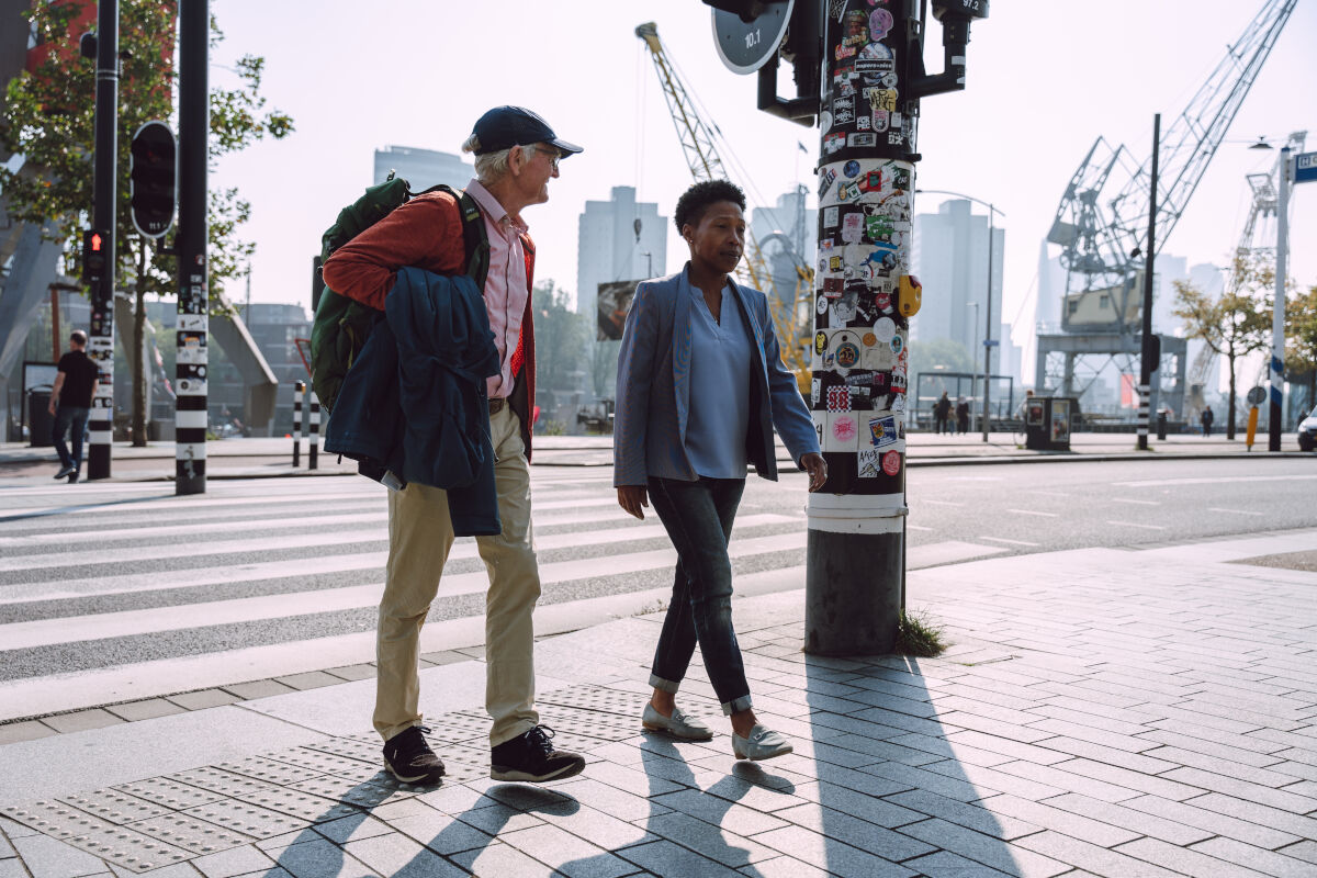 client en adviesmedewerker steken de straat over