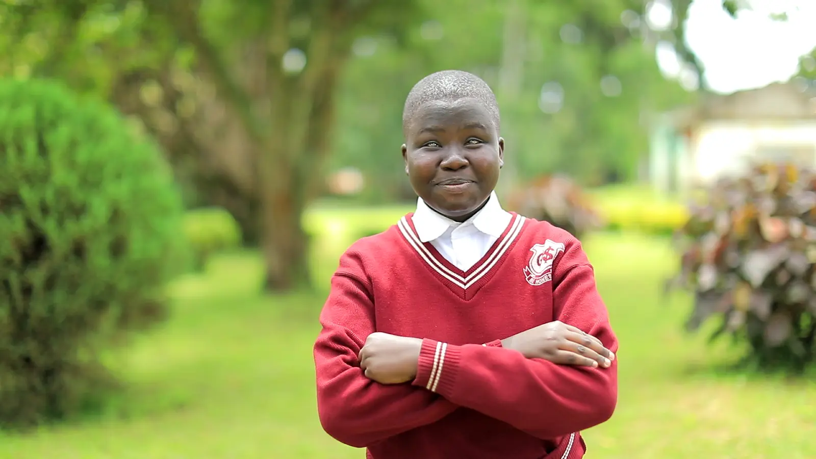 Boy with arms crossed and broad smile
