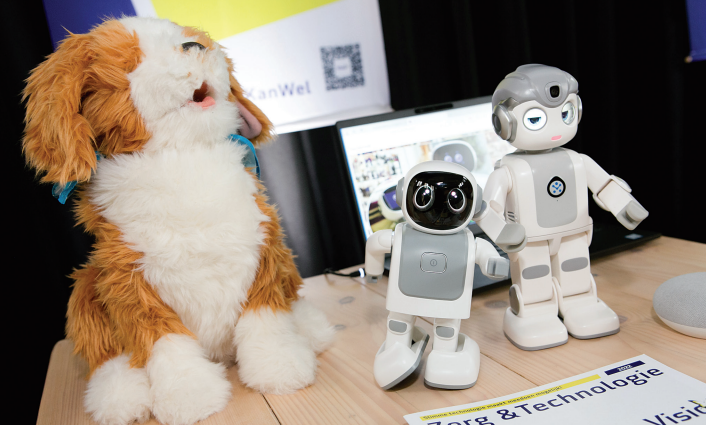 Een robothondje, en twee kleine robots staan op de afbeelding. 