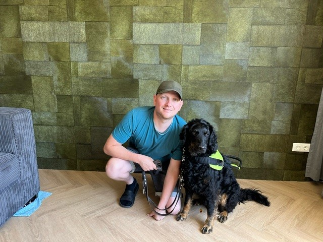 Theo van der Linden in een kamer samen met zijn blindegeleidehond