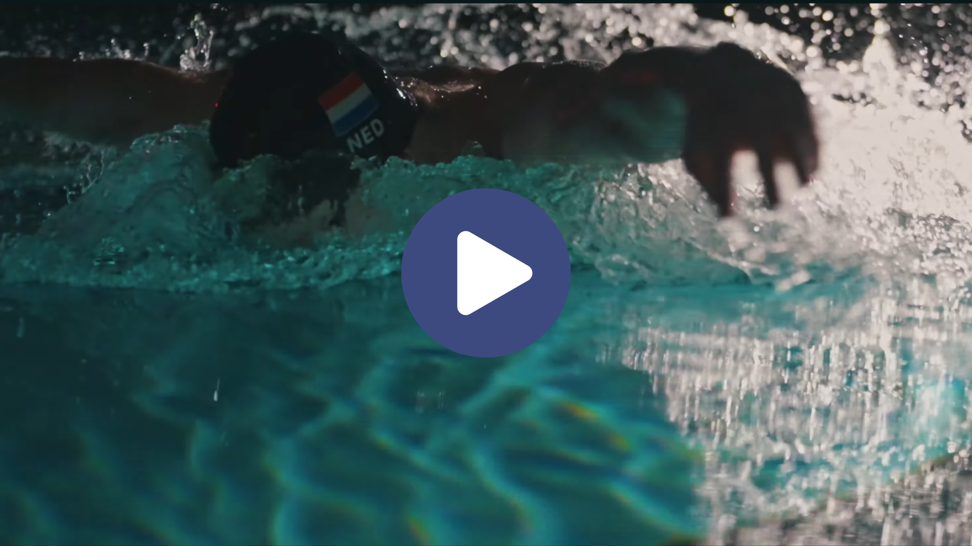 Rogier Dorsman in het water. Hij zwemt dicht bij de camera en is midden in een zwemmende beweging. Hij draagt een badmuts met de Nederlandse vlag en NED daaronder. 