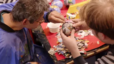 Twee mensen zijn samen creatief bezig met papier mache. Twee mensen zijn samen creatief bezig met papier mache.