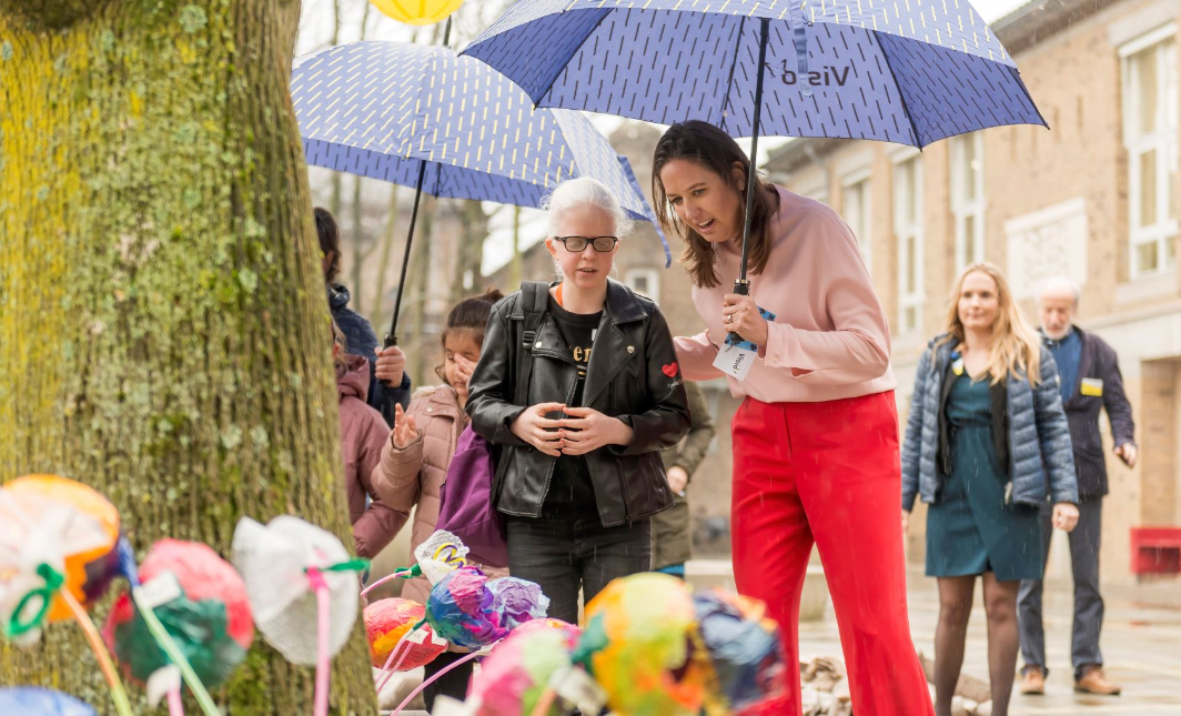 Leerling en docent kijken samen naar knutselwerkjes. 