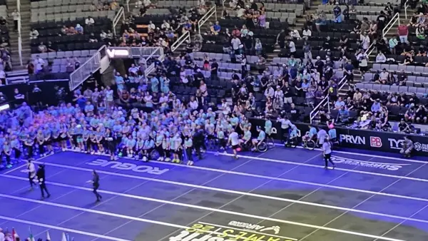 Foto van de sportzaal. De deelnemers staan in een U vorm om het midden van de zaal heen. Foto van de sportzaal. De deelnemers staan in een U vorm om het midden van de zaal heen.