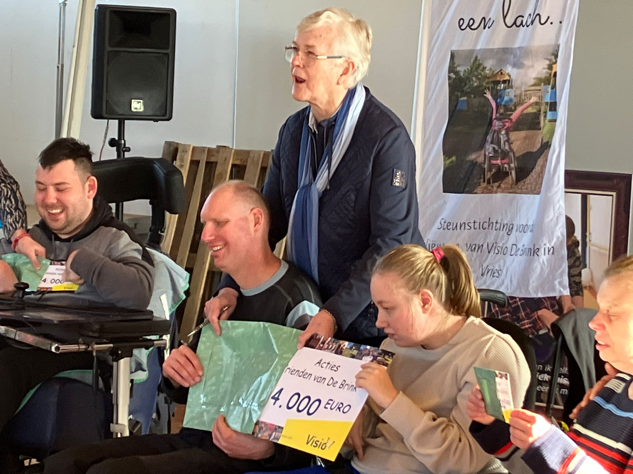 De cheque van 24000 euro wordt door de bewoners uit de envelop gehaald