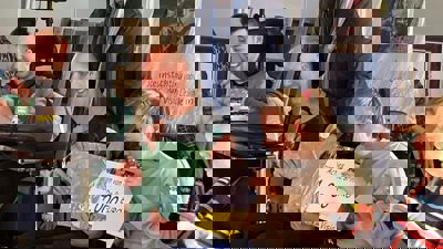 De cheque van 24000 euro wordt door de bewoners uit de envelop gehaald De cheque van 24000 euro wordt door de bewoners uit de envelop gehaald