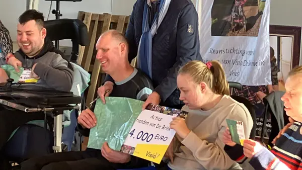 De cheque van 24000 euro wordt door de bewoners uit de envelop gehaald De cheque van 24000 euro wordt door de bewoners uit de envelop gehaald