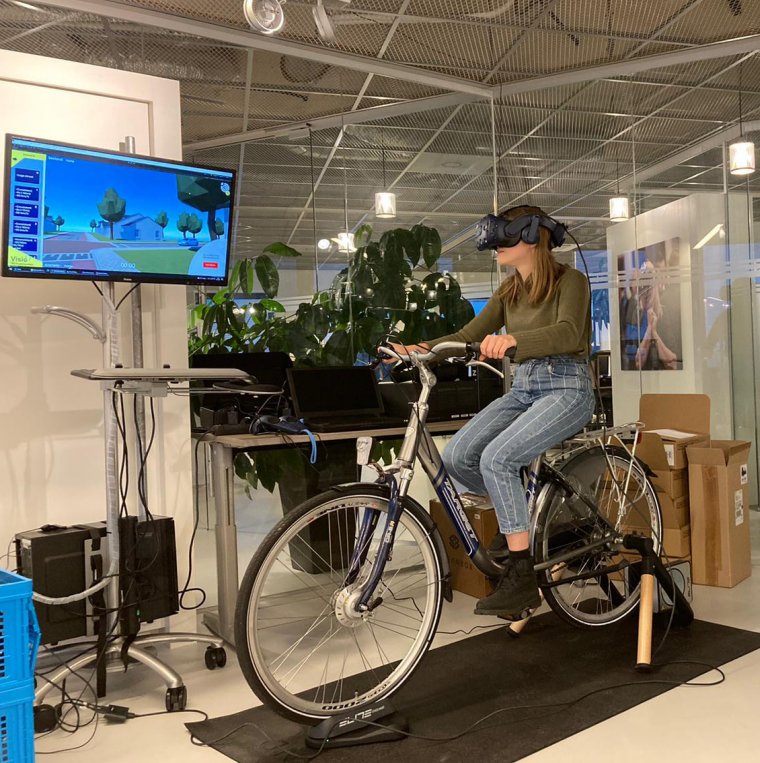Eva Postuma zit met vr bril op fiets 