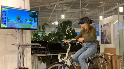 Eva Postuma zit met vr bril op fiets Eva Postuma zit met vr bril op fiets