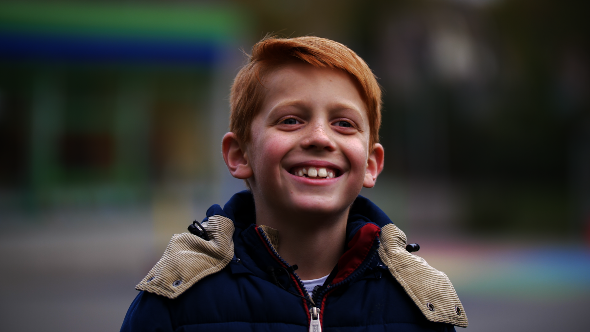 Kind met de aandoening CVI staat lachend op de foto 