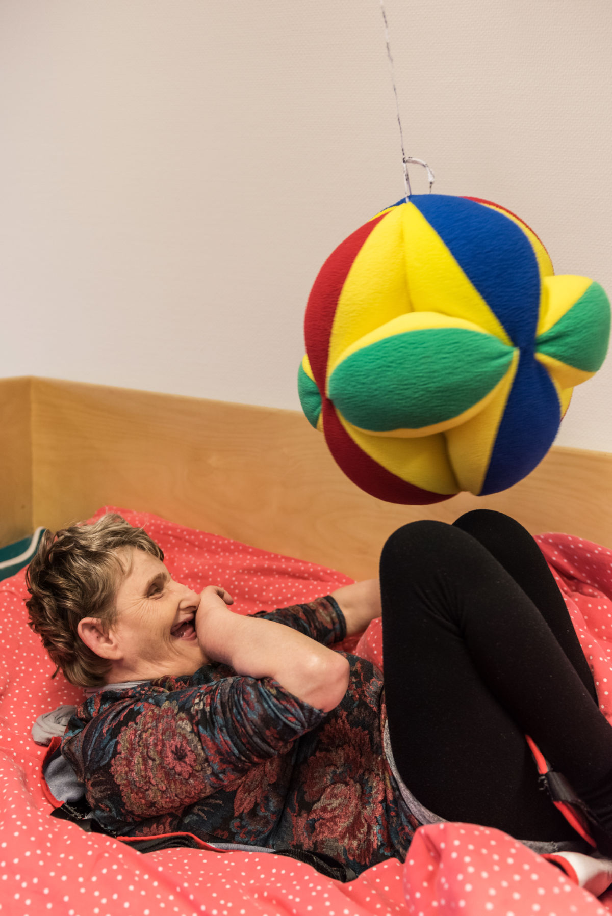 Vrouw speelt liggend in bed met een bal