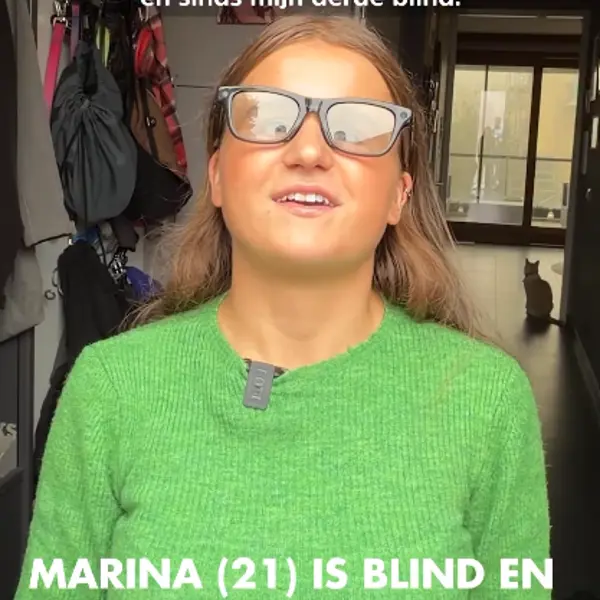 Schermafbeelding van het filmpje van Rijnmond. Marina draagt de Meta-bril en praat naar de camera. Schermafbeelding van het filmpje van Rijnmond. Marina draagt de Meta-bril en praat naar de camera.