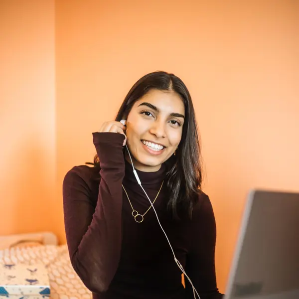 Bodhi zit op haar bed met haar laptop. Ze doet een oordopje, aangesloten aan haar laptop, in haar oor. Bodhi zit op haar bed met haar laptop. Ze doet een oordopje, aangesloten aan haar laptop, in haar oor.