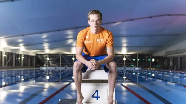 Rogier Dorsman zit naast het zwembad. Hij kijkt de camera in. Rogier Dorsman zit naast het zwembad. Hij kijkt de camera in.
