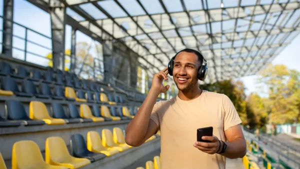 Blinde man op de tribune met koptelefoon op Blinde man op de tribune met koptelefoon op