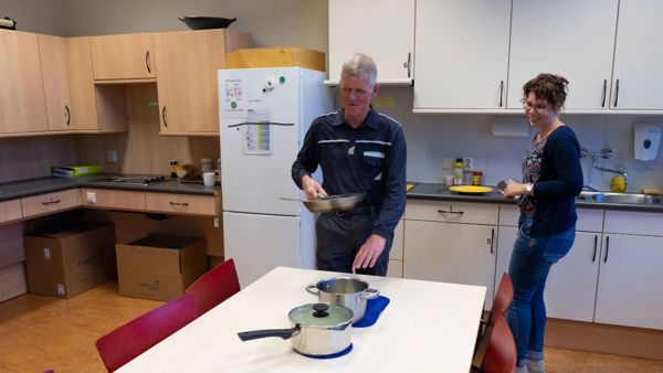 Cliënt oefent in een speciale, toegankelijke keuken van Visio Het Loo Erf met koken Cliënt oefent in een speciale, toegankelijke keuken van Visio Het Loo Erf met koken